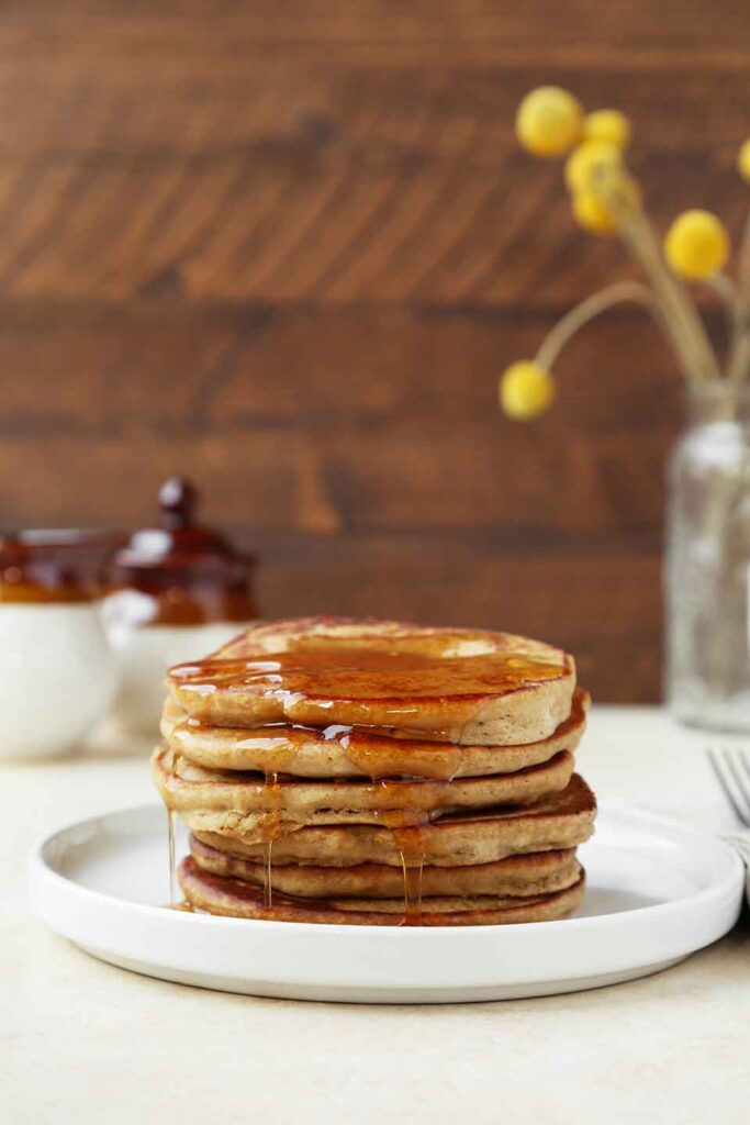 Teff pancakes stacked with syrup drizzled